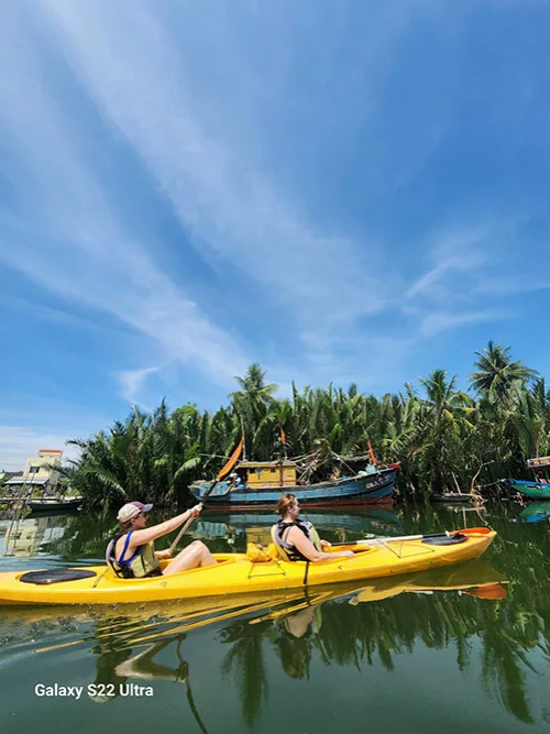 Two women appreciating the traditional fishing boats on the river as they row