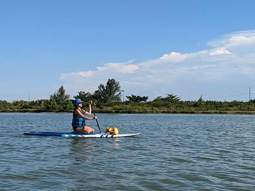 Woman lazy paddling on her SUP over the tranquil waters of the river