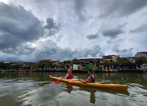 An adult couple entering the Old Tow of Hoian as they paddle on the river