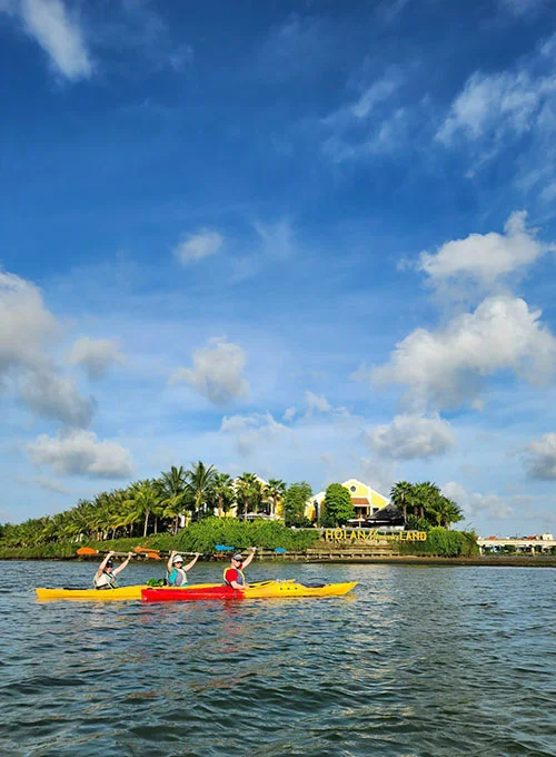 Two happy travelers on their kayak passing by on eof the islands on the river.