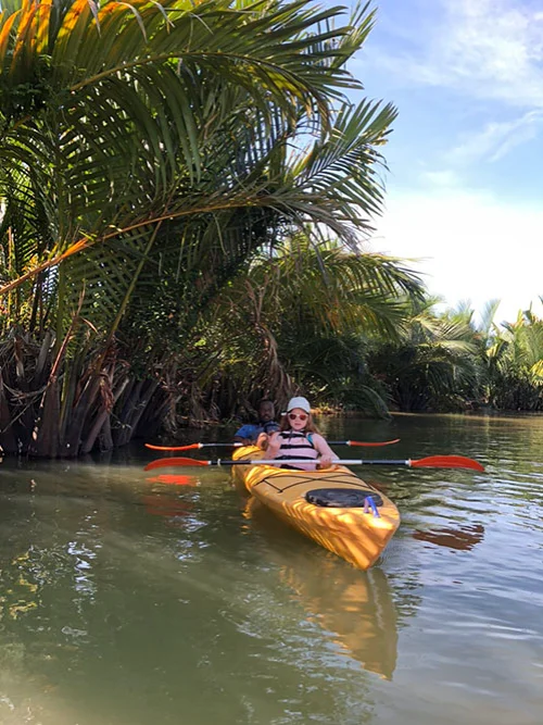 A women on her kayak resting under the shadow of the Nipa palms