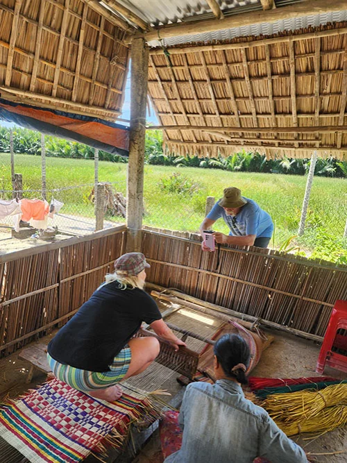 Two tourist trying to weave at the village Hoian