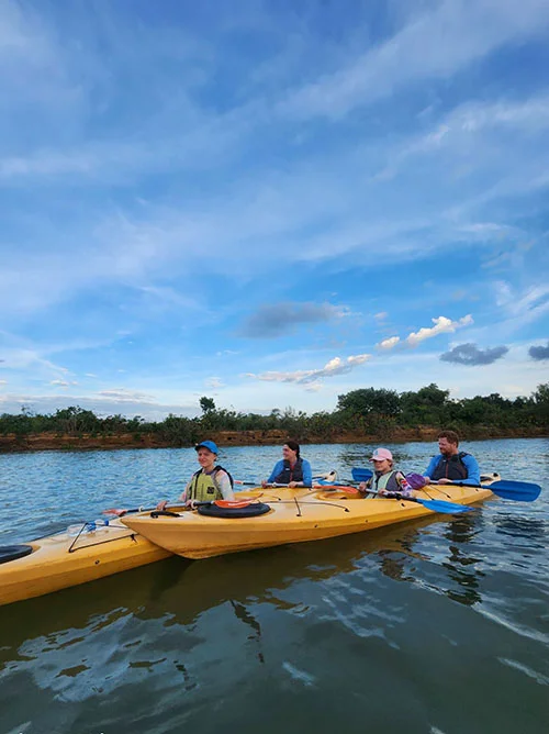 A group of friends in their kayak taking a break from rowing on the tranquil waters of the river