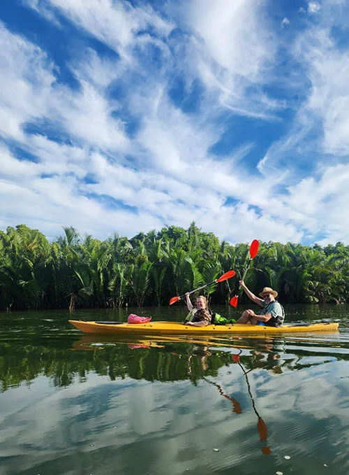 An adult couple raising their rows as a sign of joy during their river paddling