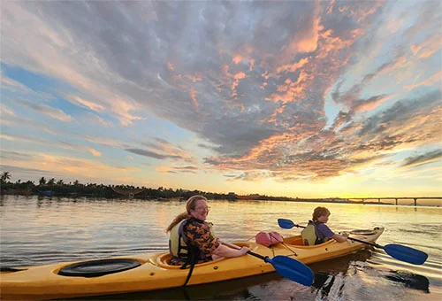 Mom and sun kayaking on the Thu Bon River in Hoian in early morning